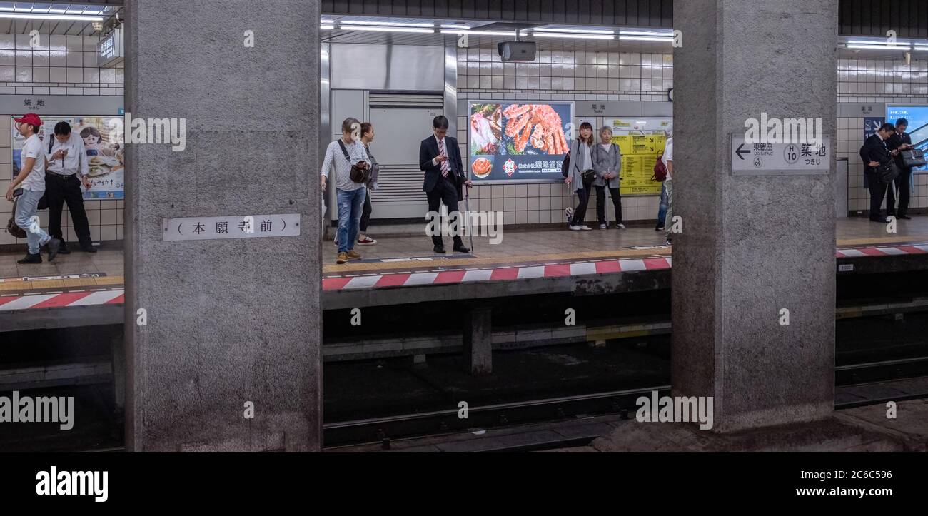 Pendolari alla stazione della metropolitana Tokyo Metro Hibiya Line, Tokyo, Giappone. Foto Stock