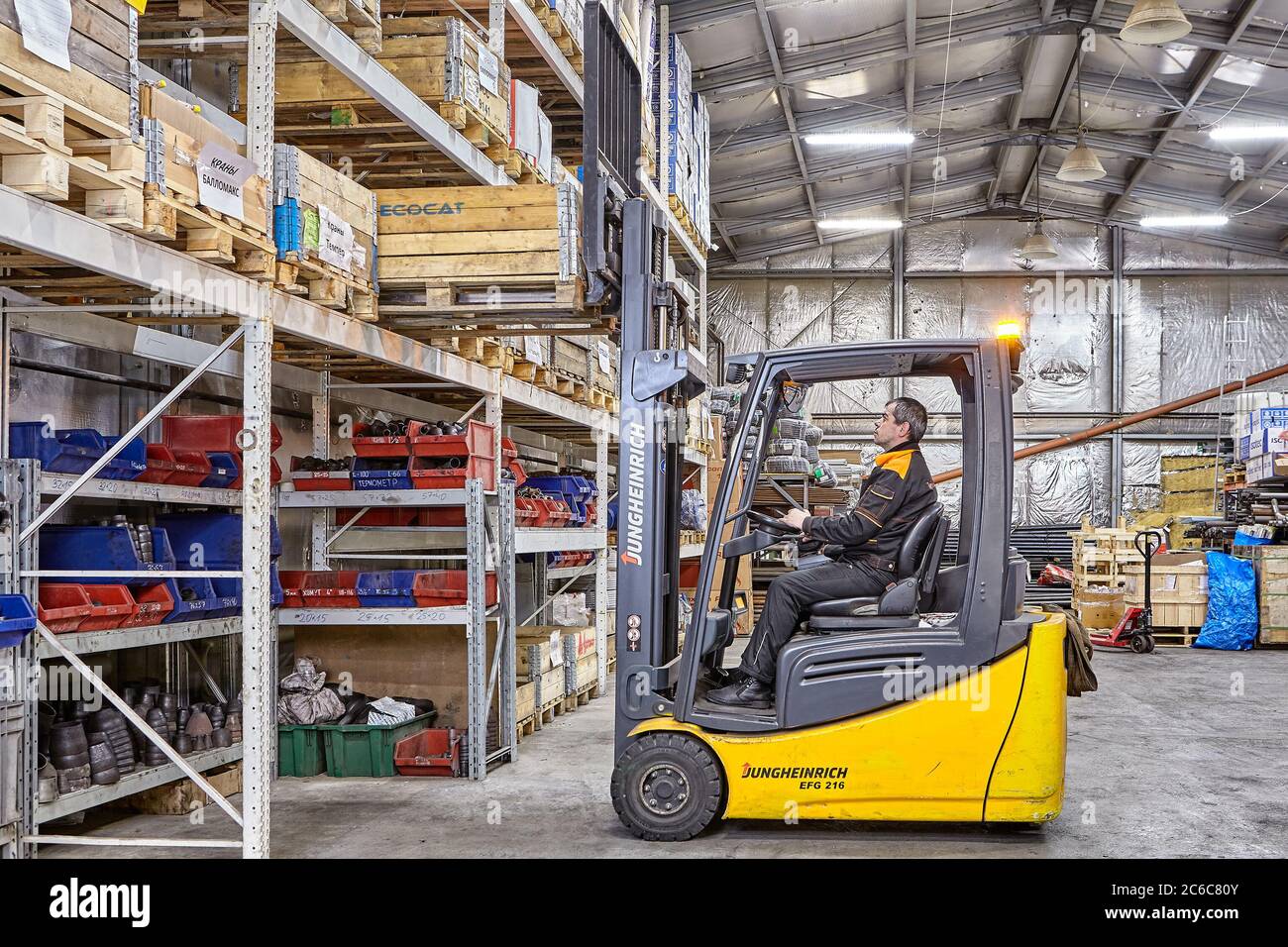 San Pietroburgo, Russia - 24 dicembre 2018: Un carrello elevatore a forche rimuove un pallet di merci da un rack in un magazzino di attrezzature di fabbrica. Sistema di stoccaggio a. Foto Stock