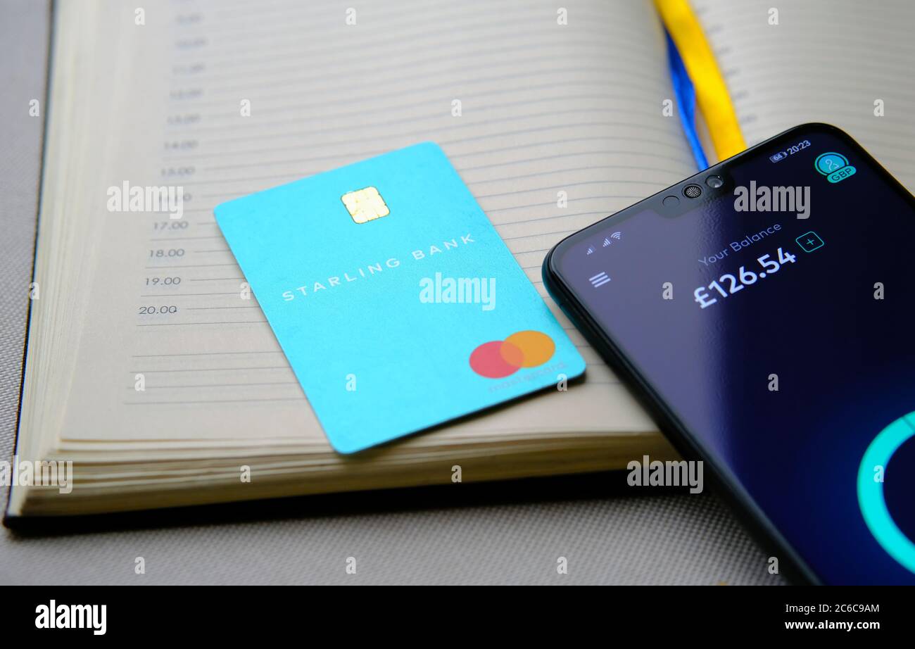 Stone / UK - 8 luglio 2020: La carta Starling Bank è posizionata in cima al diario e smartphone con l'app Starling che mostra il saldo sullo schermo. Foto Stock