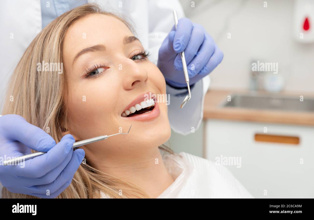 Donna che ha denti esaminati presso dentisti. Sbiancamento dei denti, concetto di cura dentale Foto Stock