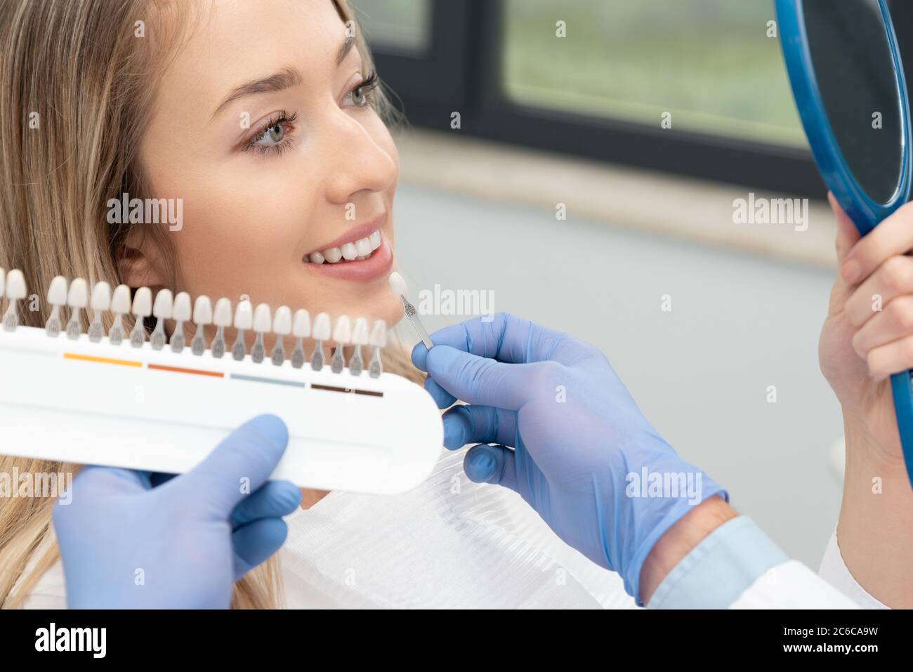 Bella giovane donna in clinica stomatologica. Denti sani sbiancanti. Foto Stock