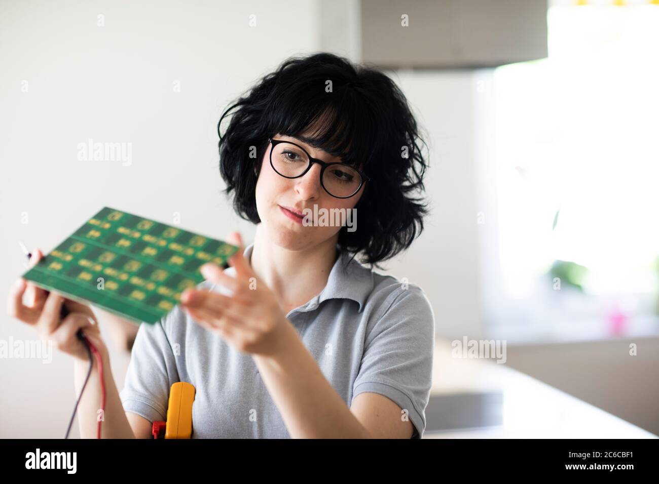 giovane donna che lavora come tecnico di elettronica Foto Stock