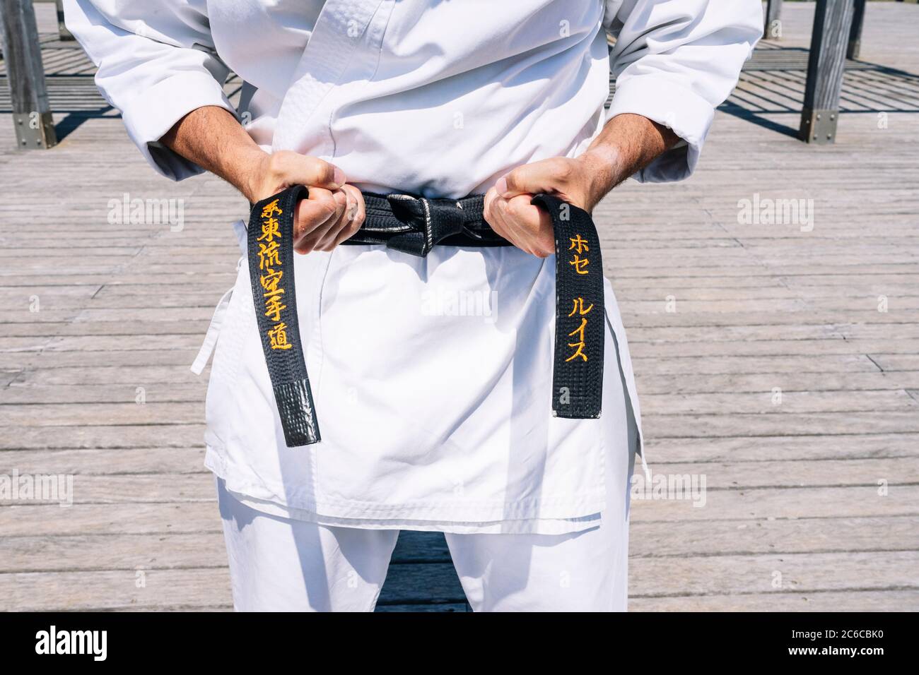Karate uomo legando il nodo della sua cintura nera Foto stock - Alamy