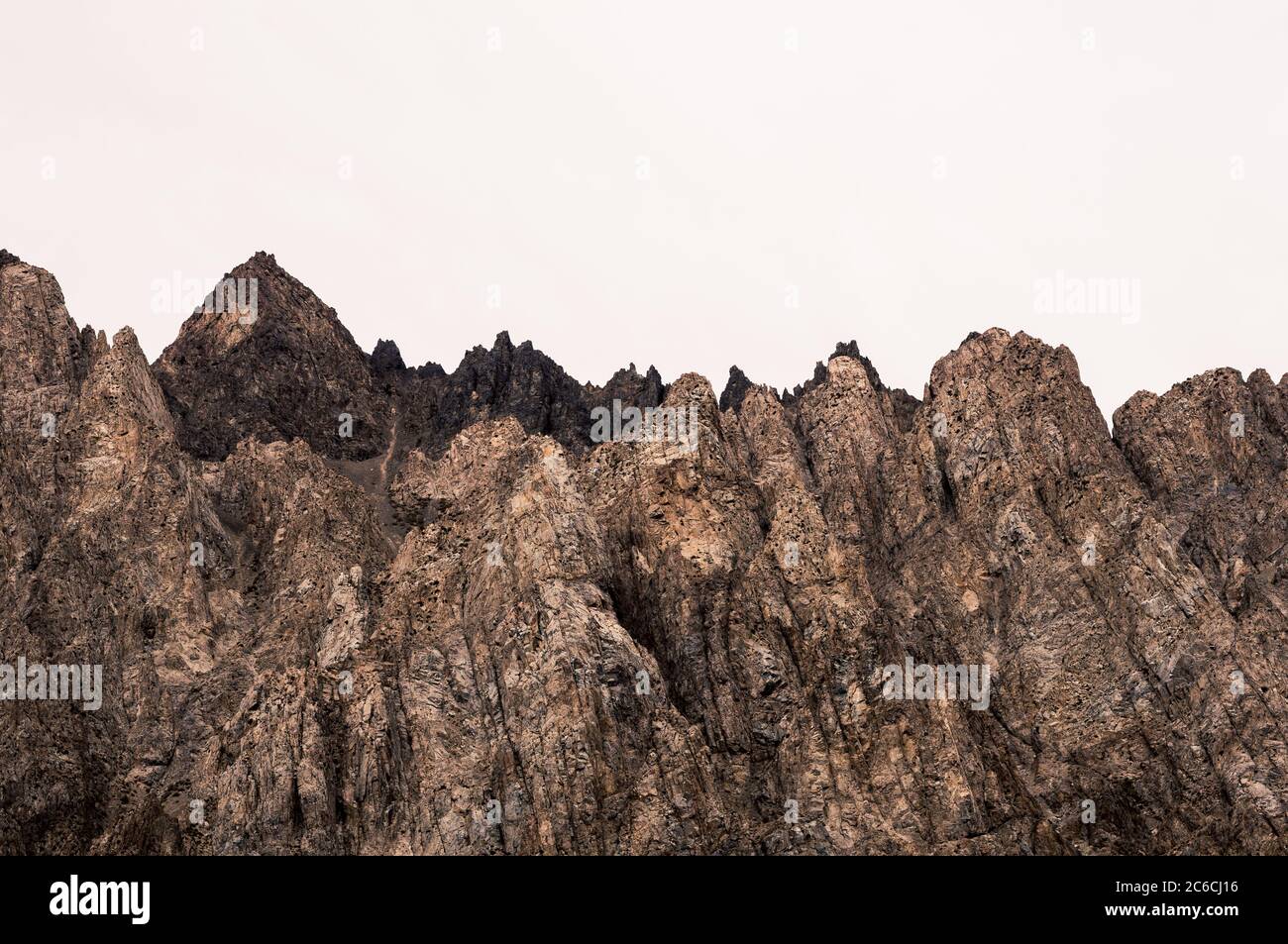 Vista della cima della montagna puntinata e della sua struttura marrone in una giornata nuvolosa. Foto Stock