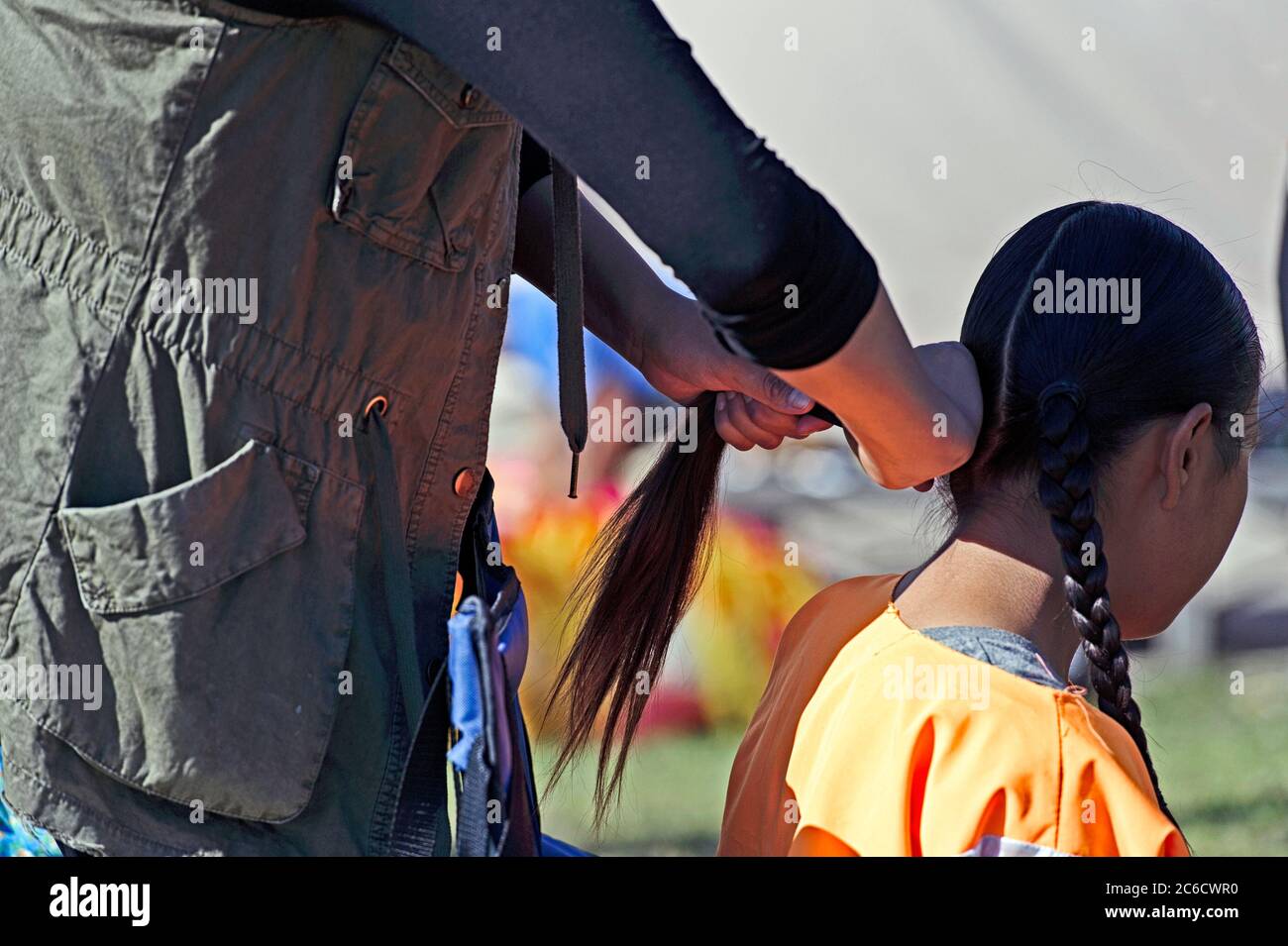 Una giovane ragazza che si è intrecciata i capelli al Tsuut'ina Nation Powwow, Bragg Creek Alberta Canada Foto Stock