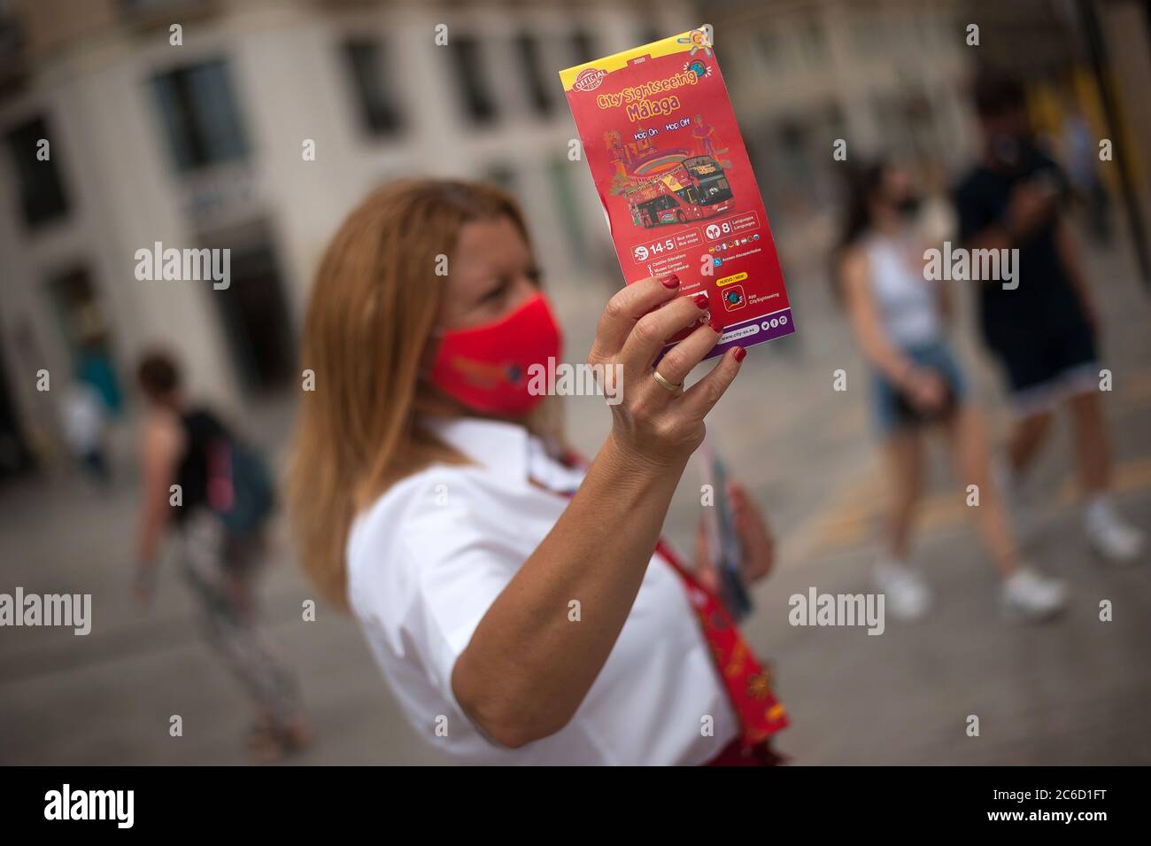 Un dipendente della 'City sightseeing' compagnia di autobus turistici è visto mostrare un opuscolo informativo a Marques de Larios Street.Spaniards continuare a vivere la vita quotidiana sotto la nuova normalità dopo la crisi Covid-19. Poiché il governo spagnolo cerca di promuovere il settore turistico internazionale con misure di sicurezza e certificati di "Covid free" nei loro luoghi turistici, In alcune parti del paese compaiono nuovi focolai di coronavirus, tuttavia le autorità andaluse riferiscono che i casi di focolaio sono sotto controllo, in quanto cercano di promuovere un'immagine turistica di fiducia e di destinazione sicura Foto Stock