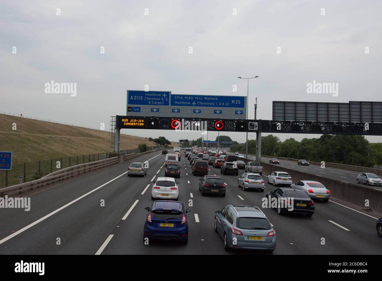 Traffico lento sull'autostrada M25 verso lo svincolo 14 con limite di velocità variabile di 40 KM/H. Foto Stock