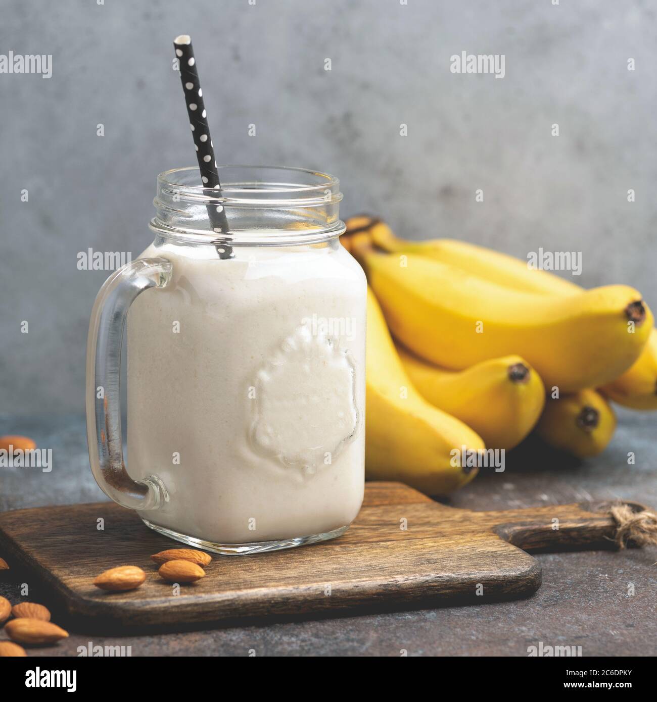 Frullato vegetariano di banana alle mandorle vegane in vaso di vetro. Frullato proteico sano di banana Foto Stock