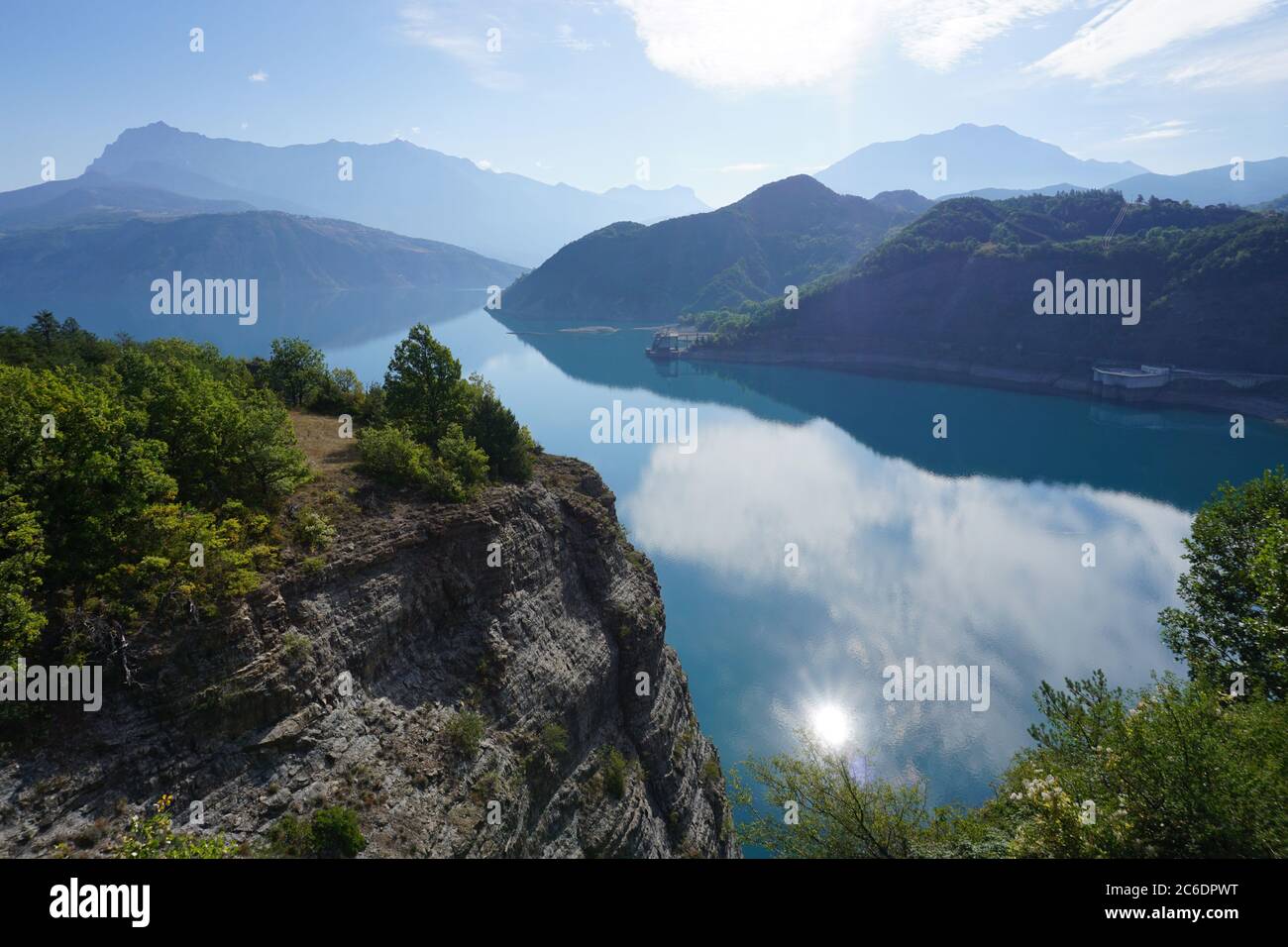 sole che si riflette nel lago serre ponçon, in francia, in una giornata molto tranquilla e luminosa Foto Stock