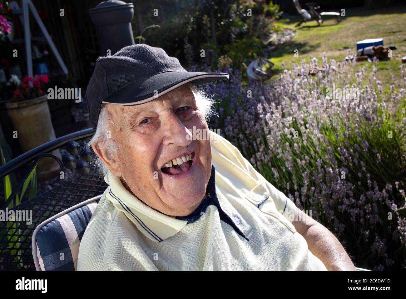Anziano nei suoi anni '80 godendosi seduto al sole, Inghilterra, Regno Unito Foto Stock