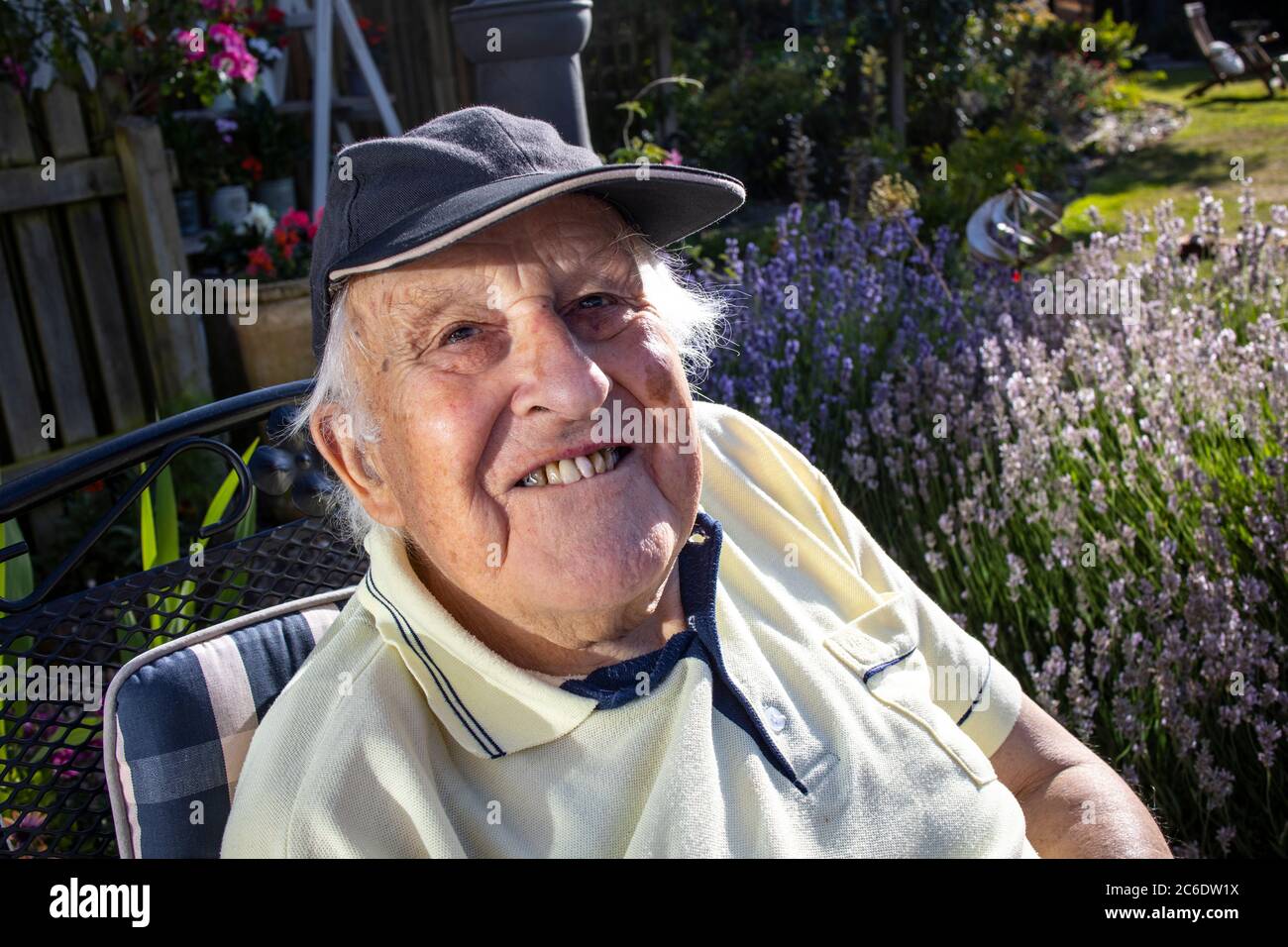 Anziano nei suoi anni '80 godendosi seduto al sole, Inghilterra, Regno Unito Foto Stock