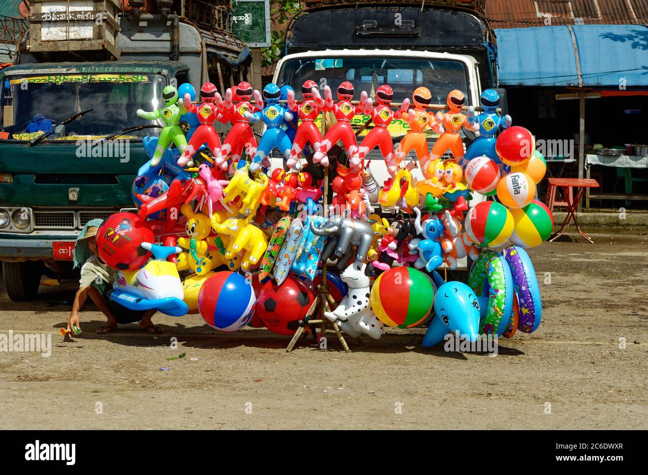 I giocattoli e i souvenir del colpo su ad un mercato in Yangon, Myanmar, compreso le sfere della spiaggia, i Rangers di alimentazione e i ballooons gialli dell'elefante. Foto Stock