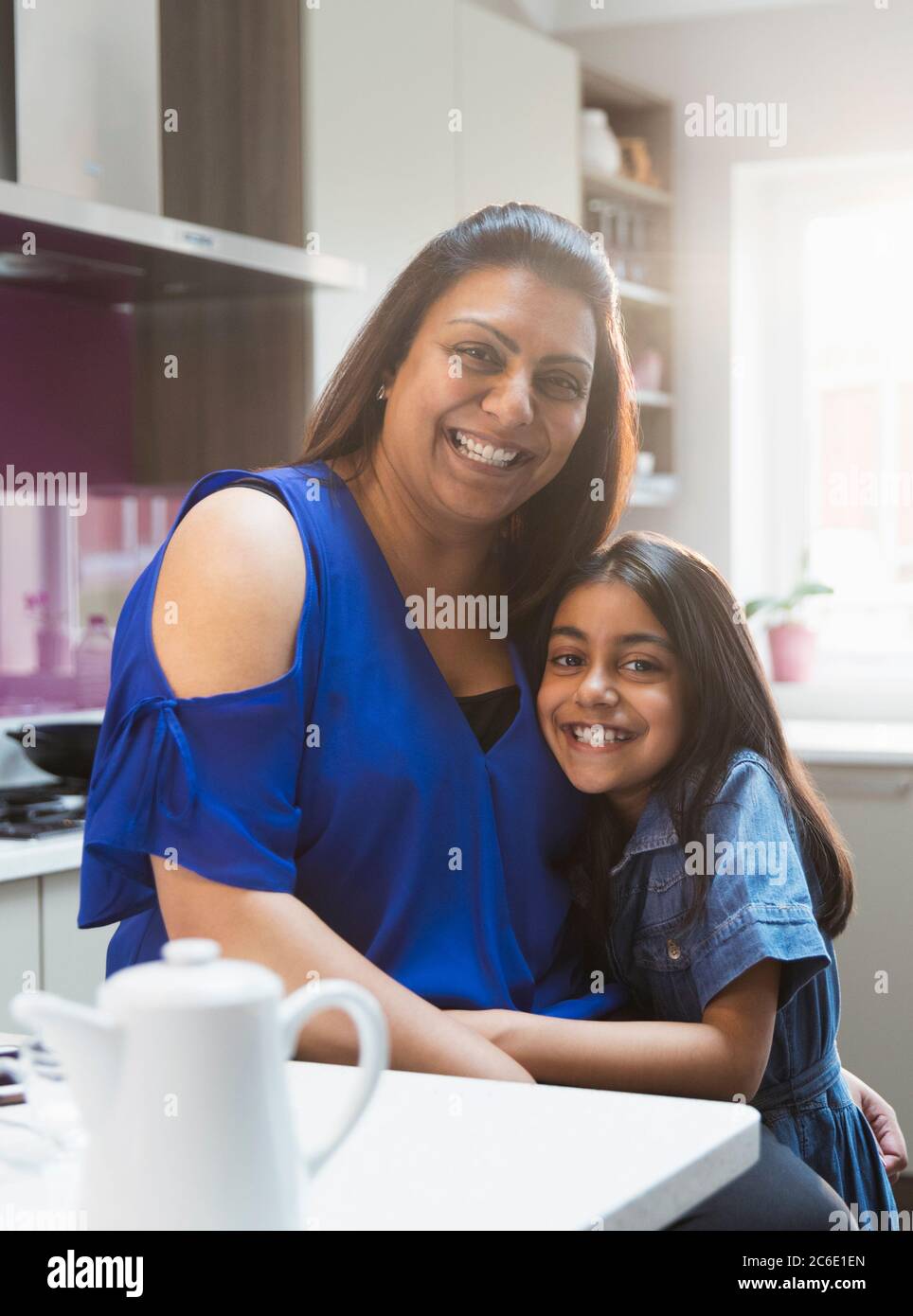 Ritratto felice madre e figlia abbracciando in cucina Foto Stock