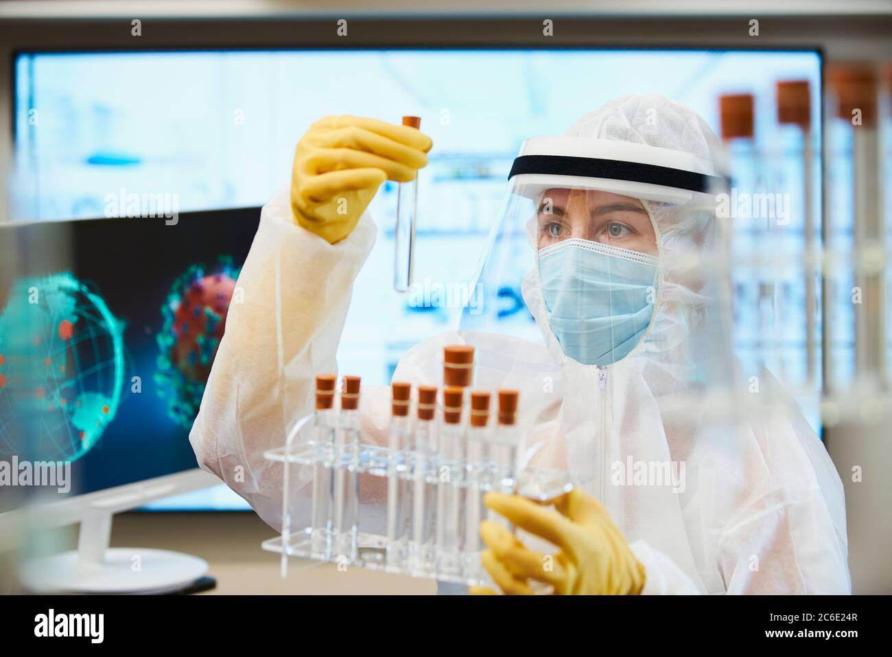 Scienziato femminile in tuta pulita che ricerca il vaccino del coronavirus Foto Stock