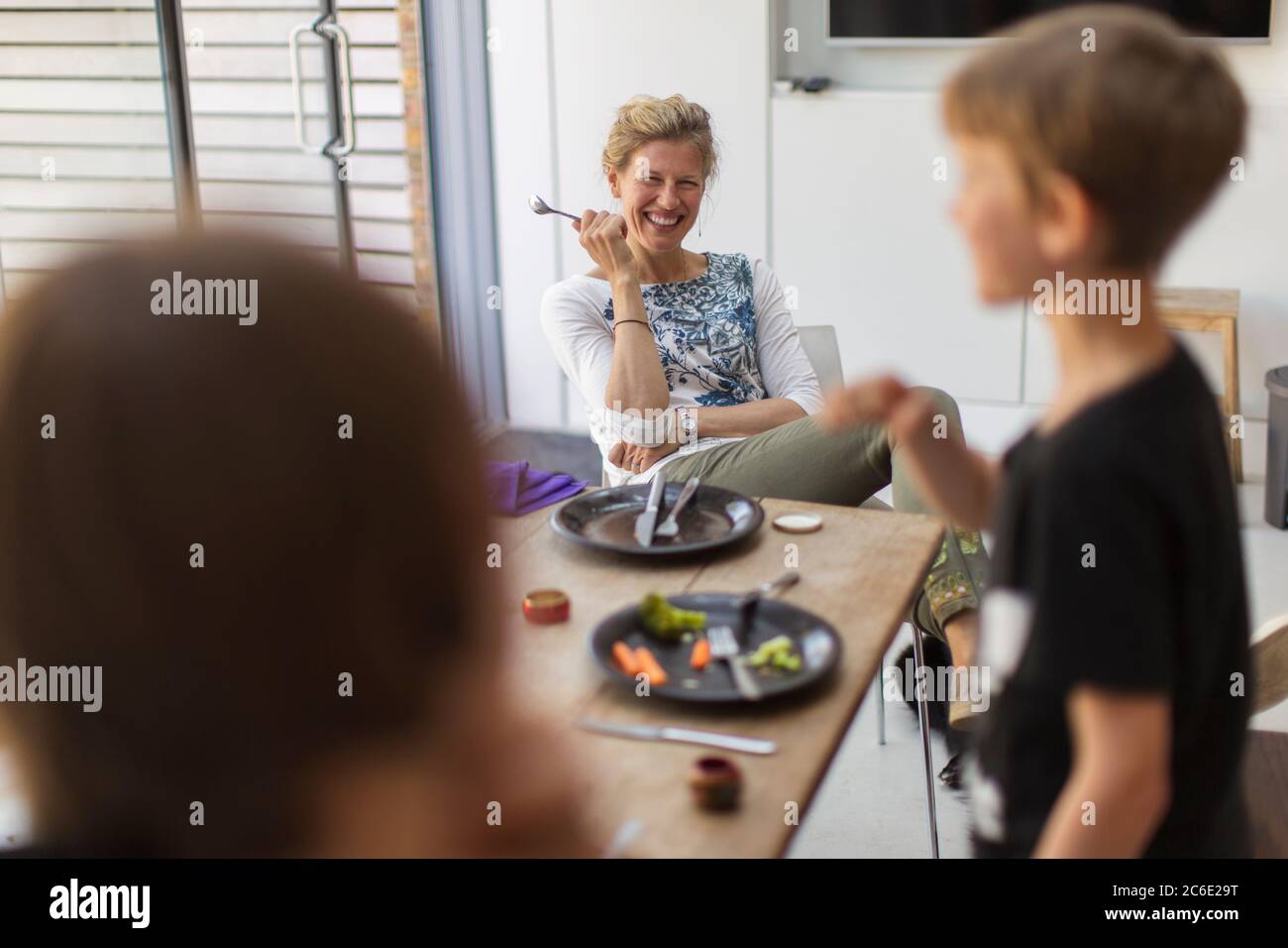 Buona madre e figli che mangiano a casa Foto Stock