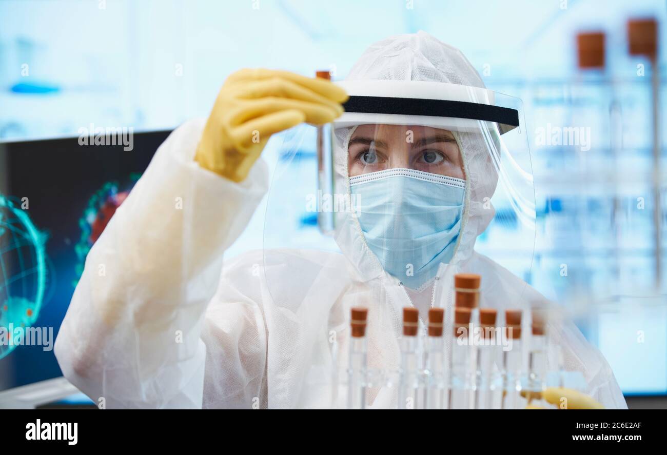 Scienziato femminile in tuta pulita che ricerca il vaccino del coronavirus Foto Stock
