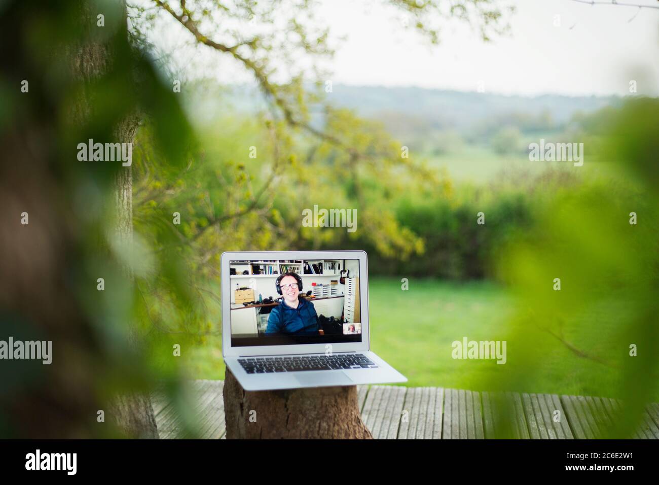 I colleghi videochattano sullo schermo del computer portatile sul balcone Foto Stock