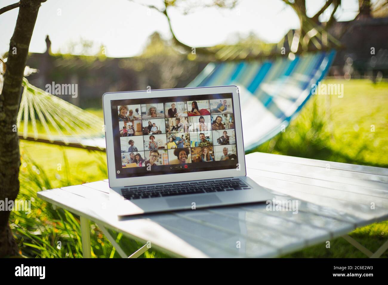 Chat video degli amici sullo schermo del computer portatile in giardino soleggiato Foto Stock