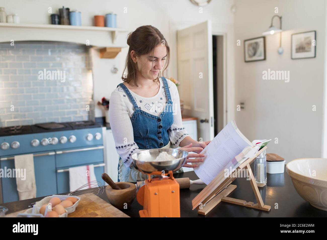 Ragazza adolescente con cookbook cottura in cucina Foto Stock