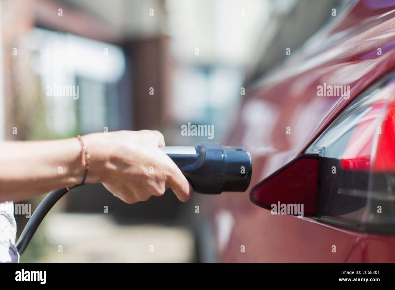 Primo piano donna che ricarica auto elettrica Foto Stock