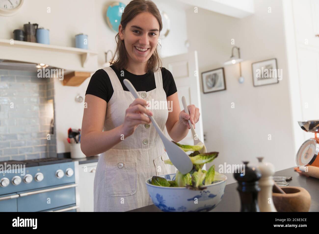 Ritratto sicuro ragazza adolescente fare insalata in cucina Foto Stock