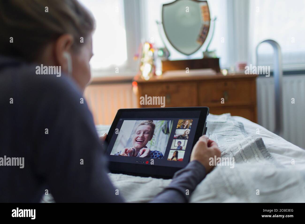 Donna con tablet digitale che parla a letto Foto Stock