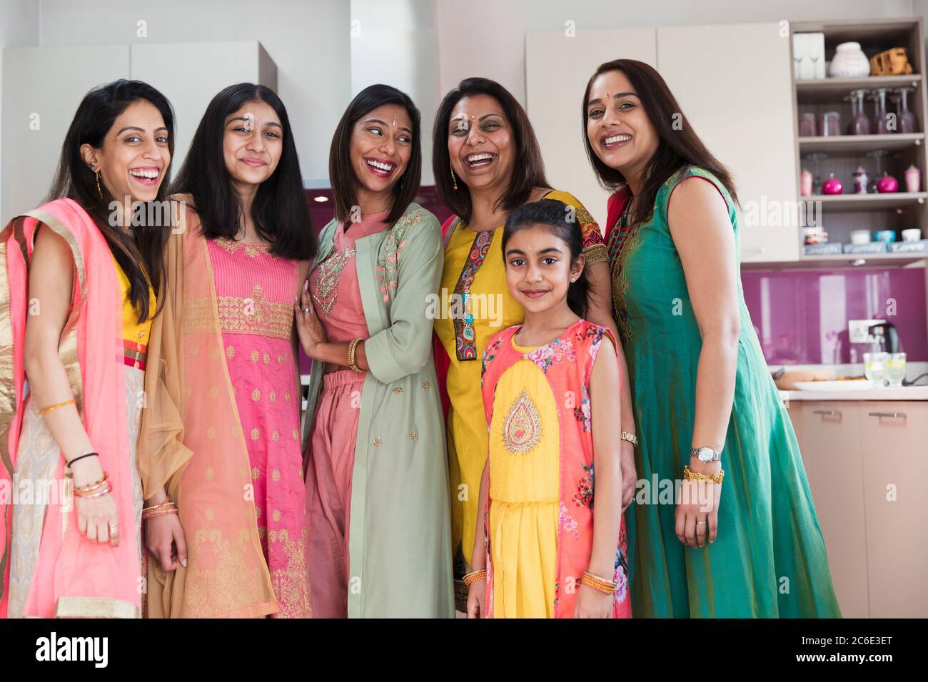 Ritratto felici donne e ragazze indiane in sari in cucina Foto Stock
