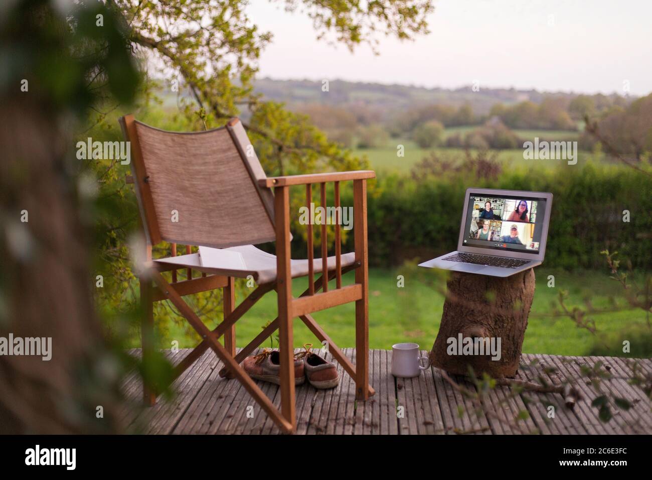 I colleghi videochattano sullo schermo del computer portatile sul balcone rurale Foto Stock