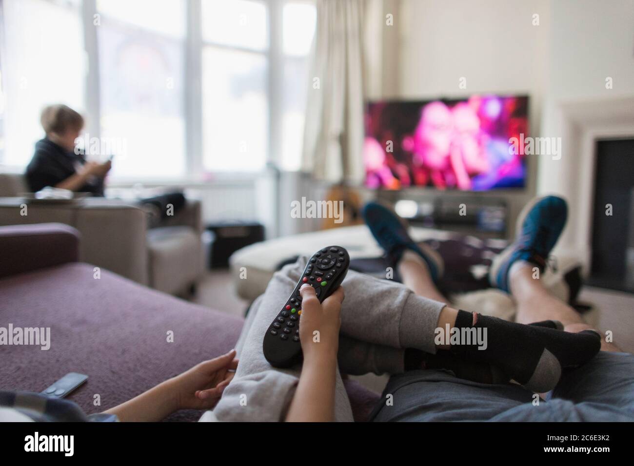 Famiglia POV con telecomando per guardare la TV in soggiorno Foto Stock