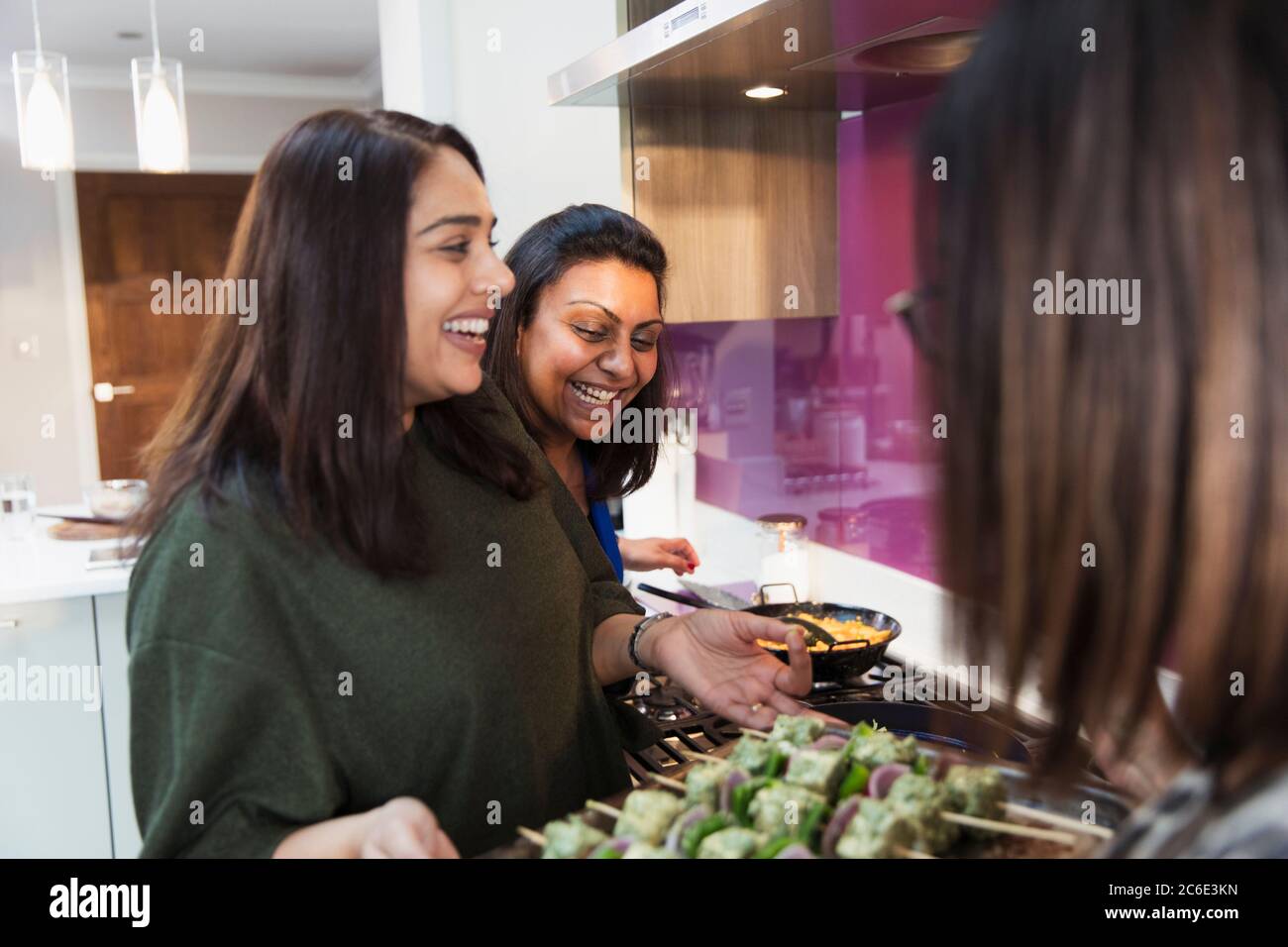 Felici donne indiane che preparano il cibo in cucina Foto Stock