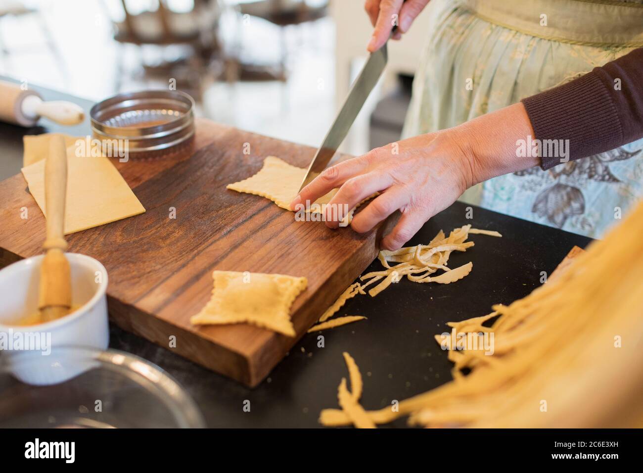 Primo piano donna che taglia pasta fresca fatta in casa Foto Stock