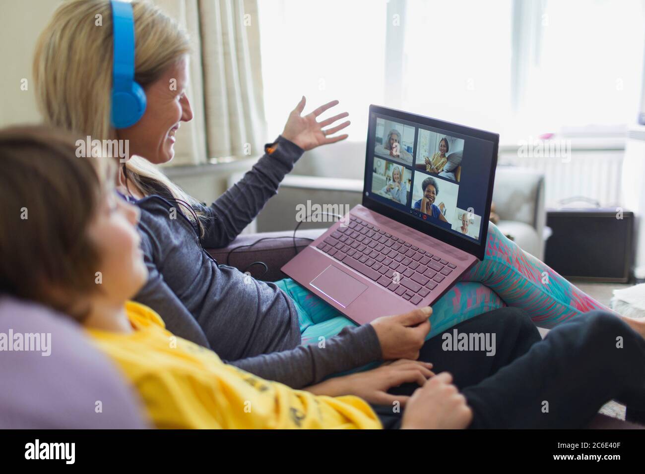 Madre e figlio con il laptop che chiacchiera sul divano Foto Stock