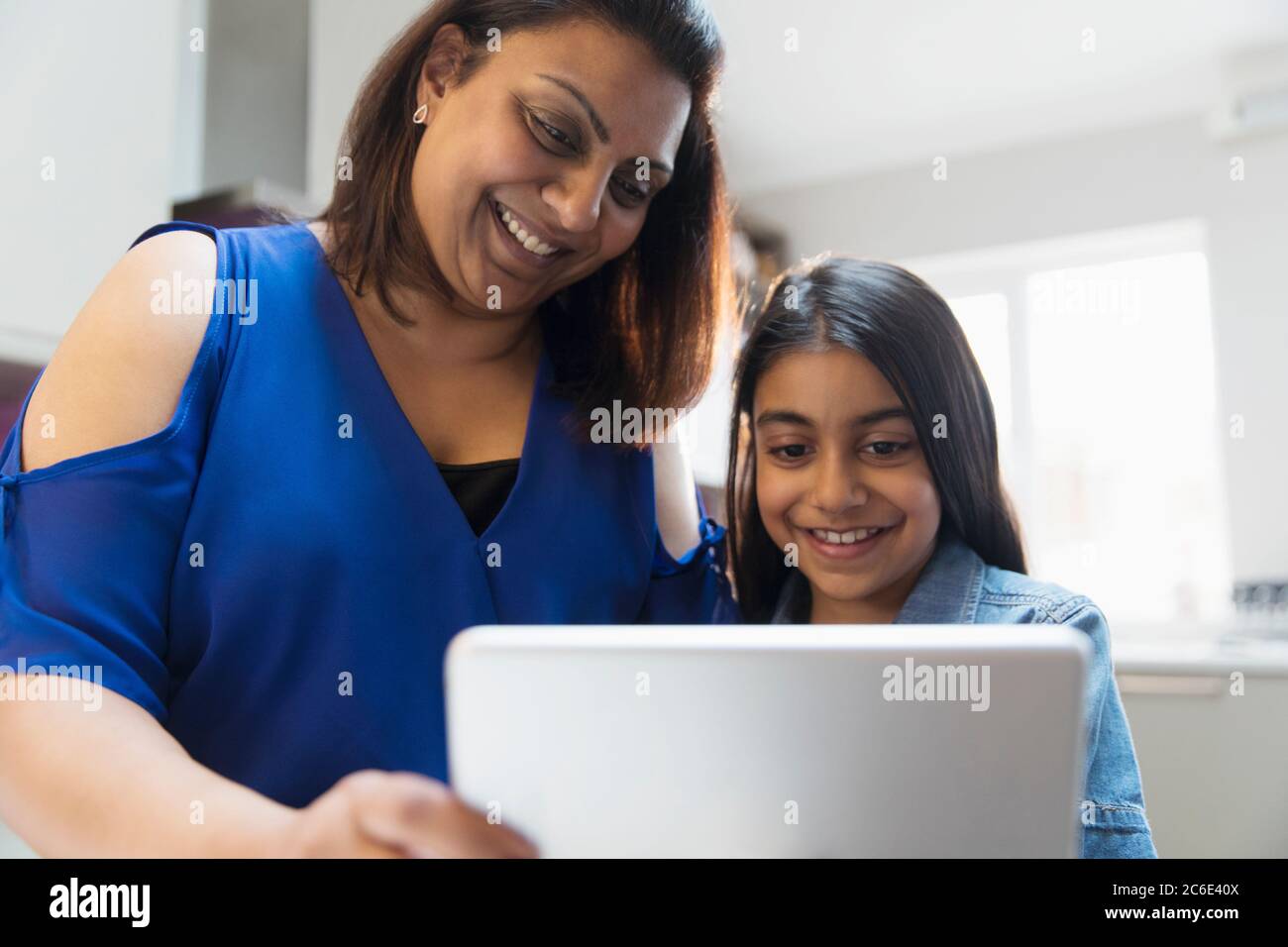 Felice madre e figlia con tavoletta digitale Foto Stock