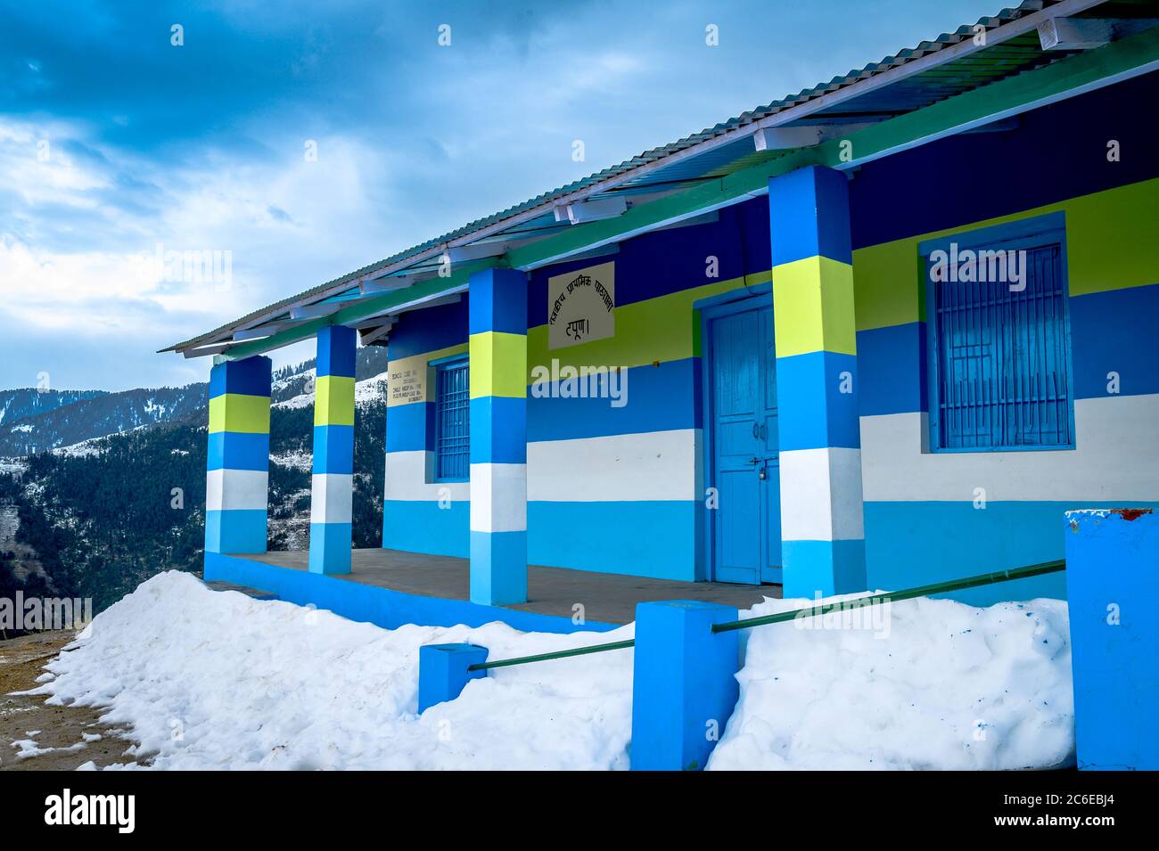 Colorato, vivace villaggio scuola in inverno sulle montagne Himalayan sulla strada per trekking Khajjiar, Himachal Pradesh, India. Foto Stock