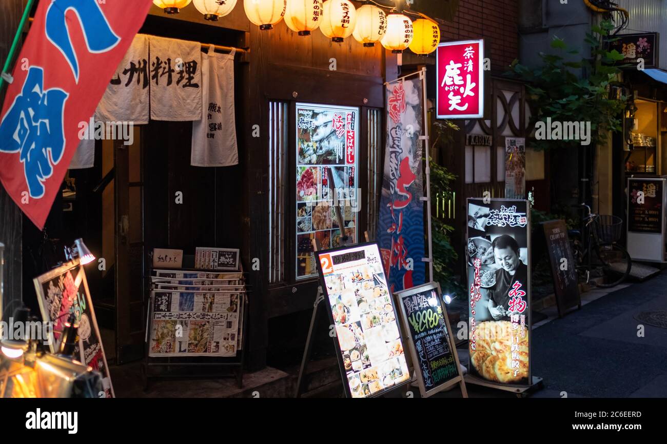 I vicoli della vecchia scuola del quartiere di Shimbashi o yokocho pieni di minuscoli ristoranti, pub e negozi, Tokyo, Giappone al tramonto. Foto Stock