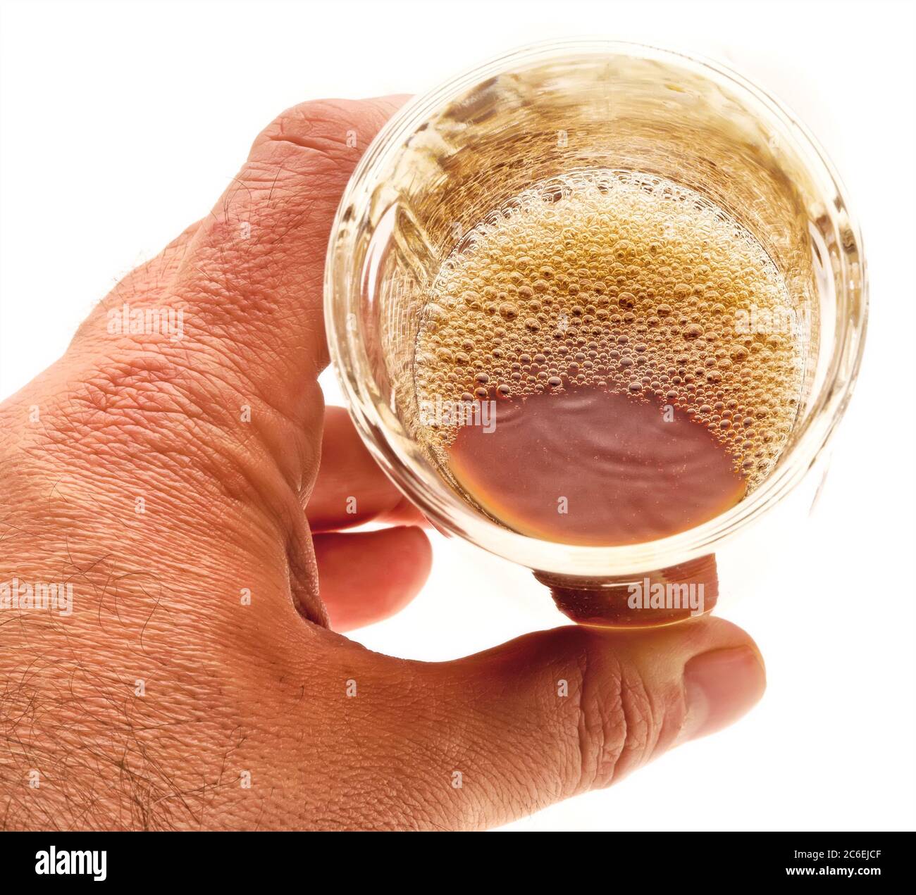 Bicchiere di birra schiumosa scura a mano maschile - scena chiave alta Foto Stock