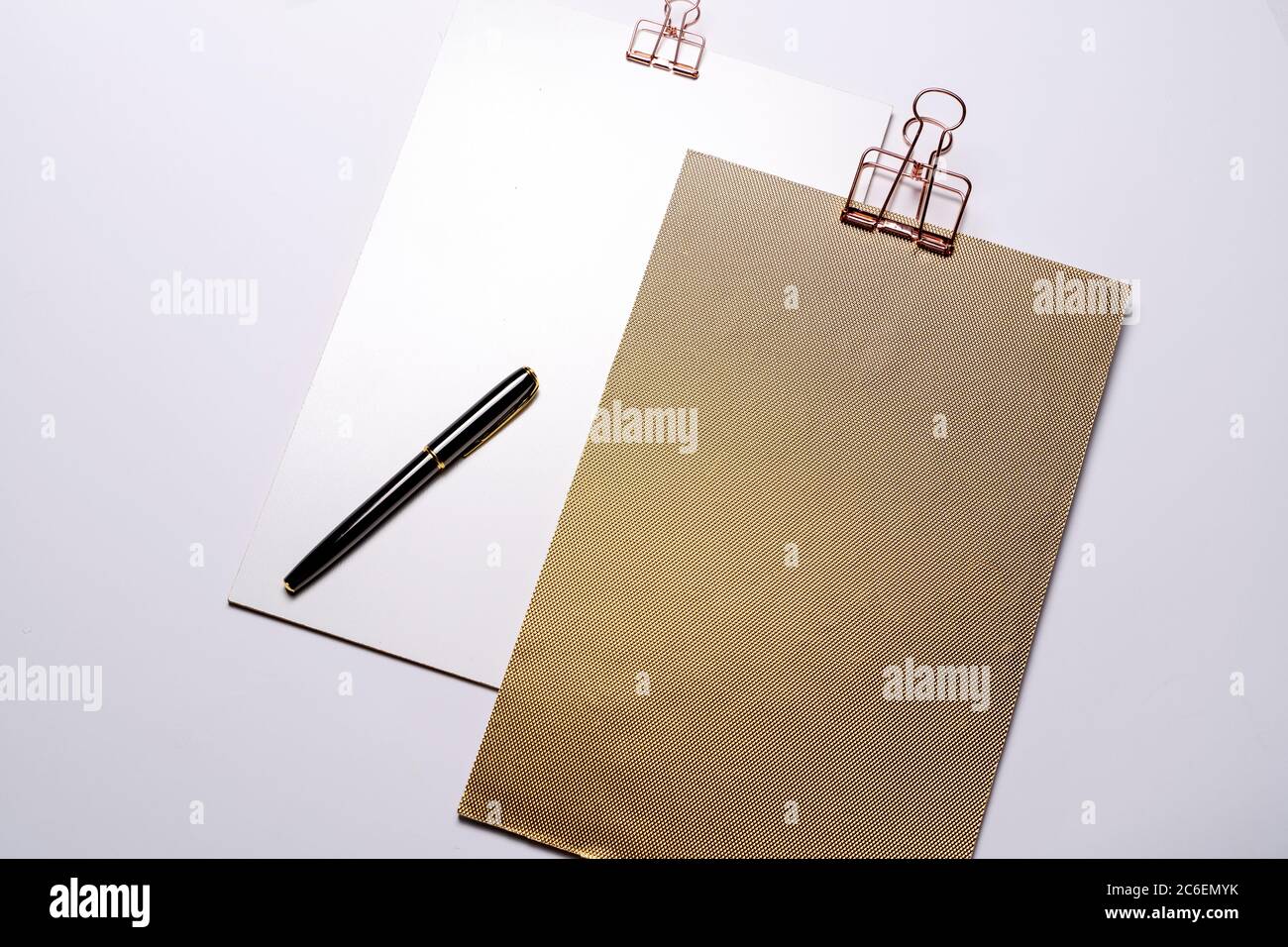 Due appunti dorati, mockup di cancelleria di marca e penna stilografica sulla scrivania sgombrata. Set di oggetti aziendali moderni, nessuno Foto Stock