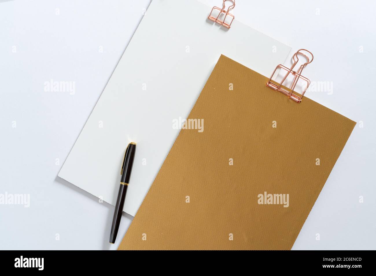 Due appunti dorati, mockup di cancelleria di marca e penna stilografica sulla scrivania sgombrata. Set di oggetti aziendali moderni, nessuno Foto Stock