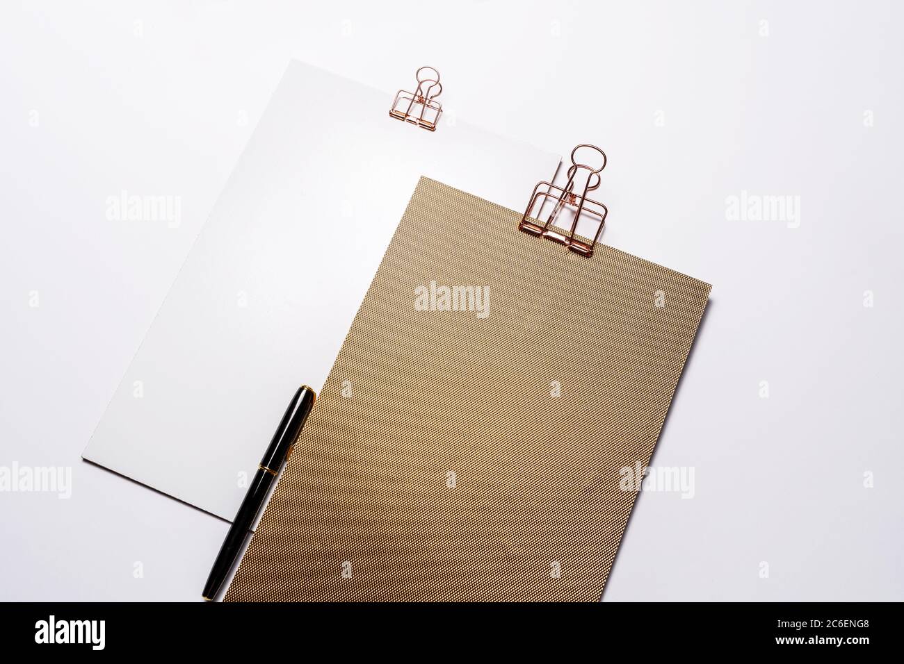 Due appunti dorati, mockup di cancelleria di marca e penna stilografica sulla scrivania sgombrata. Set di oggetti aziendali moderni, nessuno Foto Stock