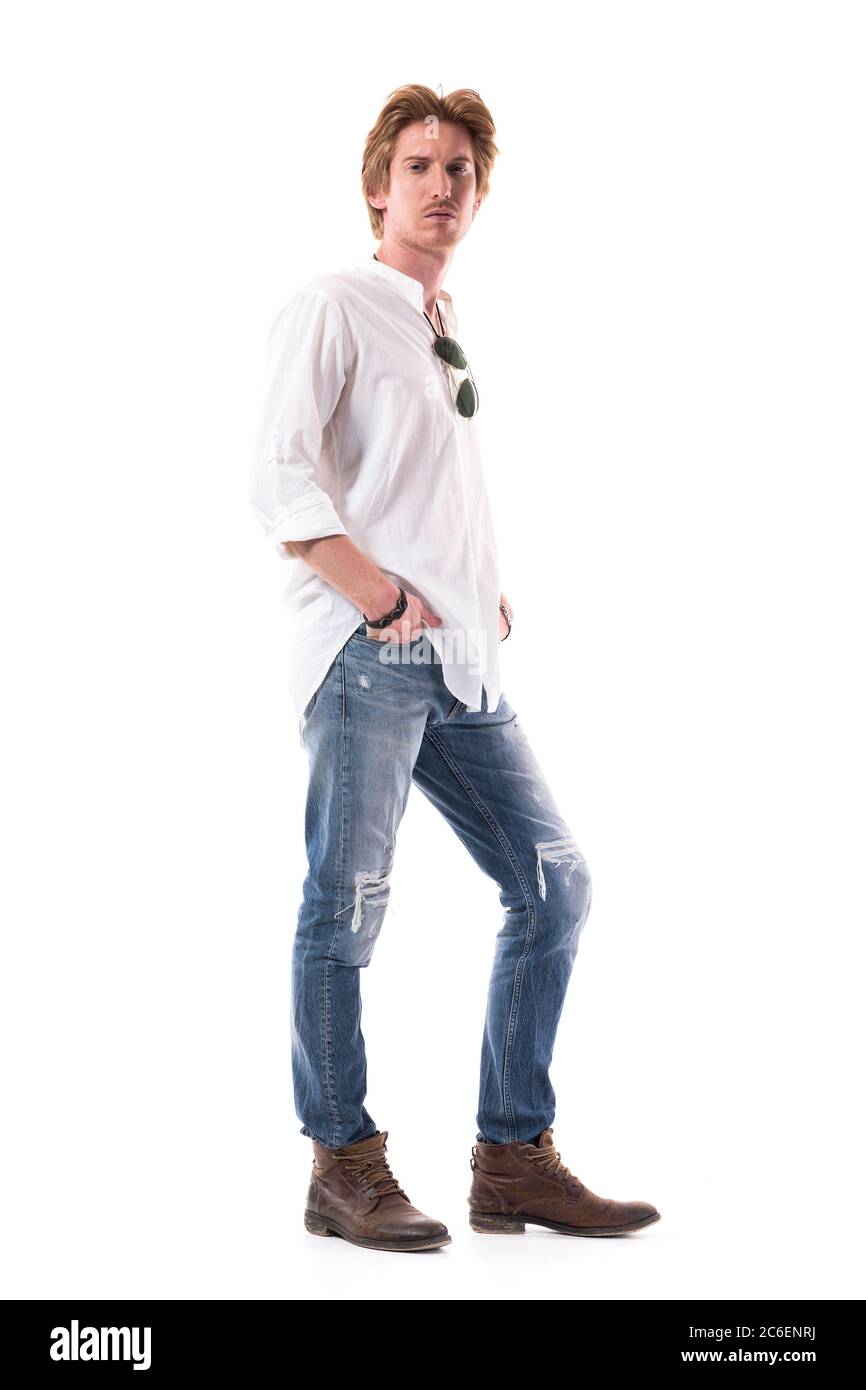 Uomo alla moda giovane e raffinato in jeans strappati e camicia bianca che  si posa con le mani in tasche. Lunghezza corpo intero isolata su sfondo  bianco Foto stock - Alamy
