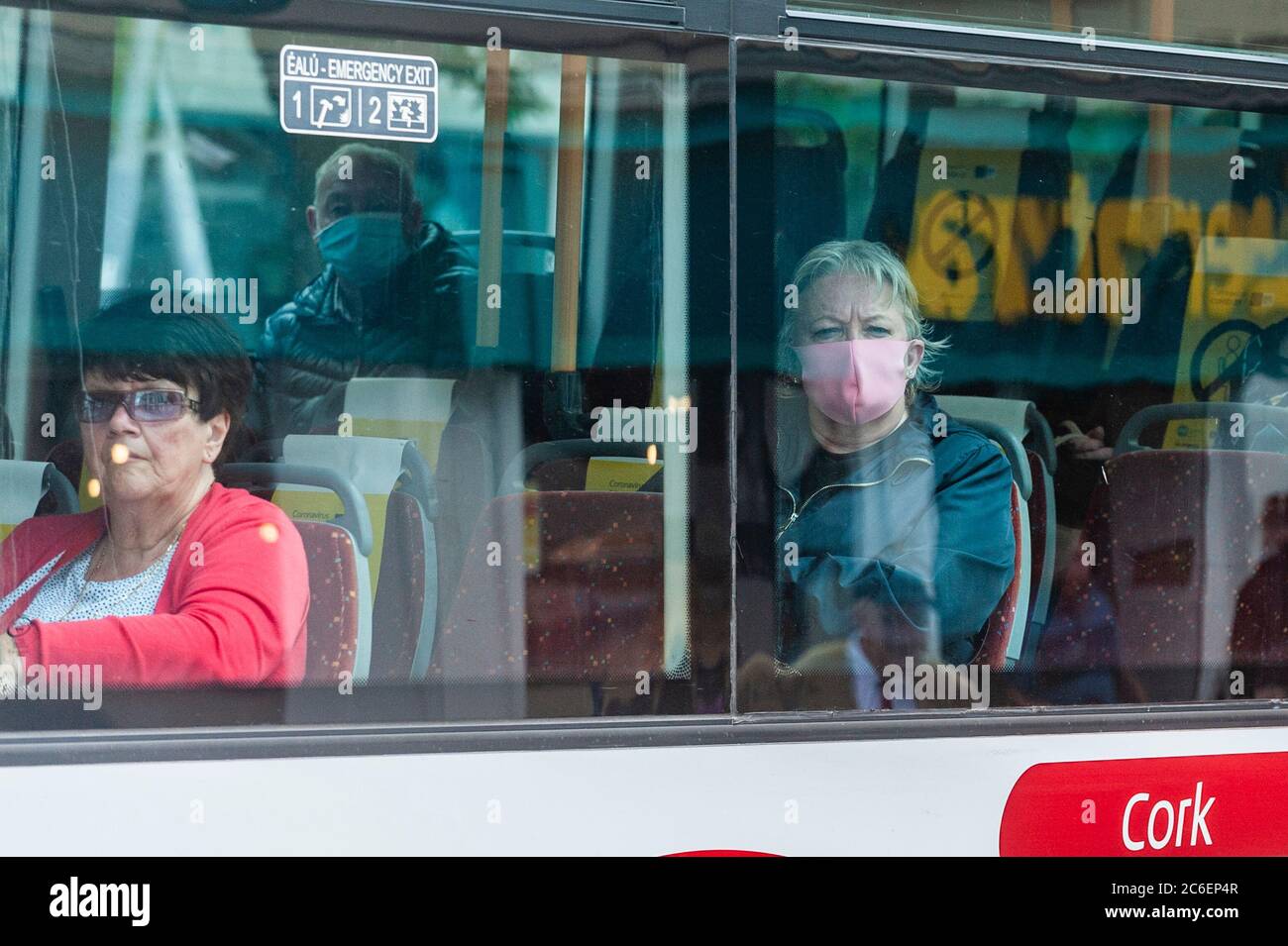 Cork, Irlanda. 9 luglio 2020. Una donna indossa una maschera facciale su un autobus Eireann in Cork città oggi, mentre un passeggero collega viaggia senza una maschera. L'uso di maschere facciali sui mezzi di trasporto pubblico è diventato obbligatorio in Irlanda lunedì 29 giugno. Credit: Notizie dal vivo di AG/Alamy Foto Stock