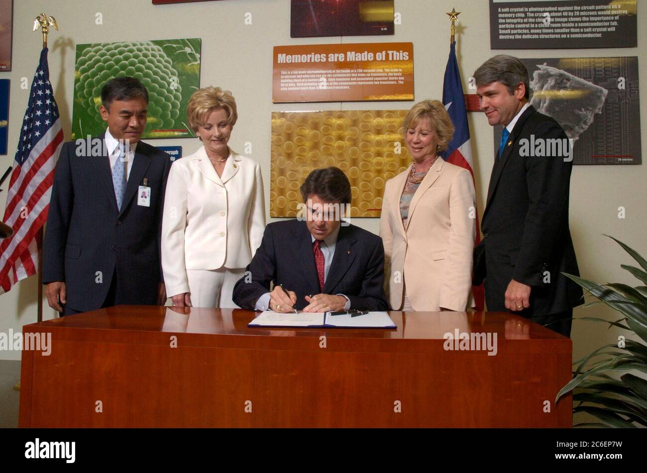 Austin, Texas USA, 13 giugno 2005: Il governatore del Texas Rick Perry (al centro, seduto) firma un disegno di legge che stimola gli investimenti nell'industria high-tech del Texas. La firma del disegno di legge avviene presso l'impianto di produzione di semiconduttori Samsung da 1,3 miliardi di dollari nella periferia nord di Austin. Da sinistra a destra ci sono il direttore dello stabilimento H.K. Park, la Rep. Di Stato Jeanne Morrison, il Governatore Perry, il Senatore di Stato Florence Shapiro e il Rep. Michael McCaul. ©Bob Daemmrich Foto Stock