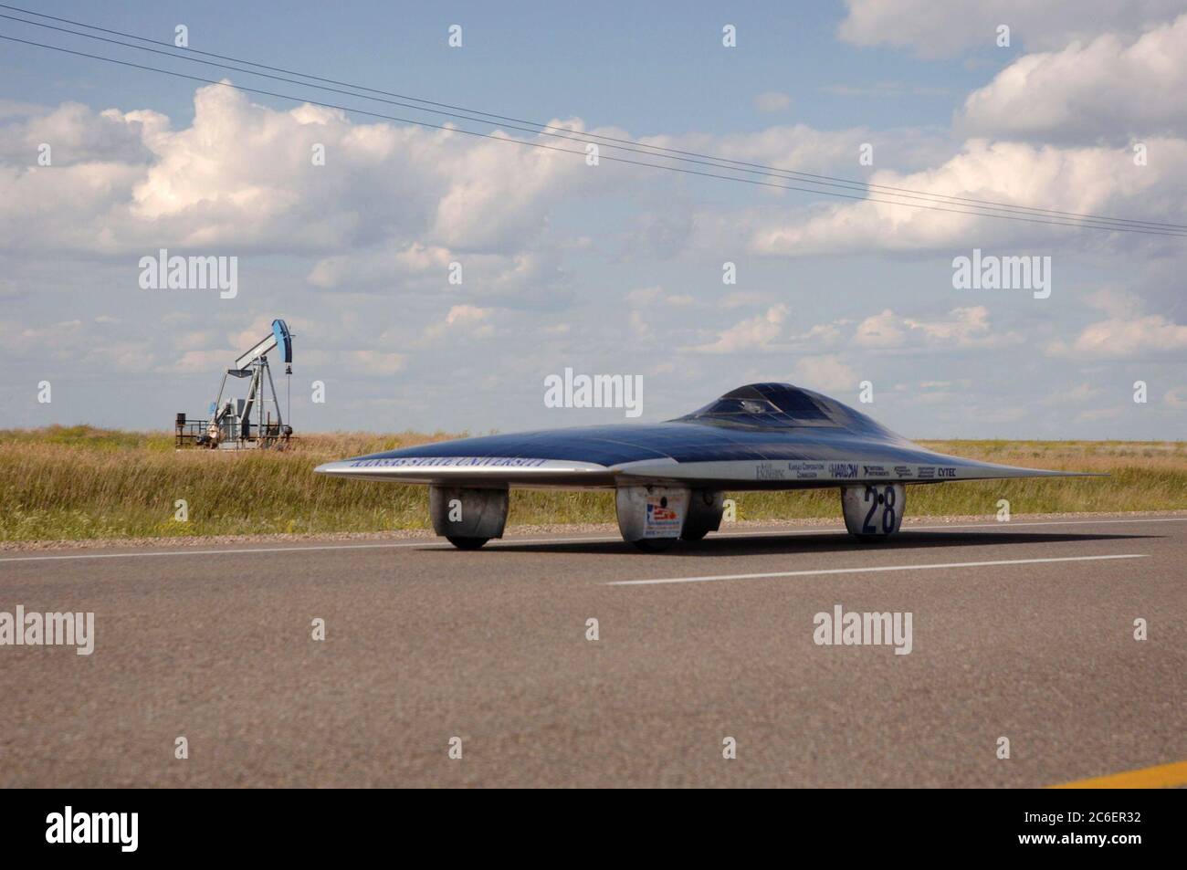 Swift Current, Saskatchewan Canada, 25 luglio 2005: L'auto solare della Kansas State University (USA) passa una pompa dell'olio nelle pianure meridionali del Saskatchewan sulla Trans Canada Highway durante la North American Solar Challenge, una gara di auto solari di 2.500 km da Austin, Texas, a Calgary, Alberta Canada. L'evento della durata di 10 giorni comprende 22 squadre universitarie e universitarie provenienti da Stati Uniti e Canada. ©Bob Daemmrich/ Foto Stock