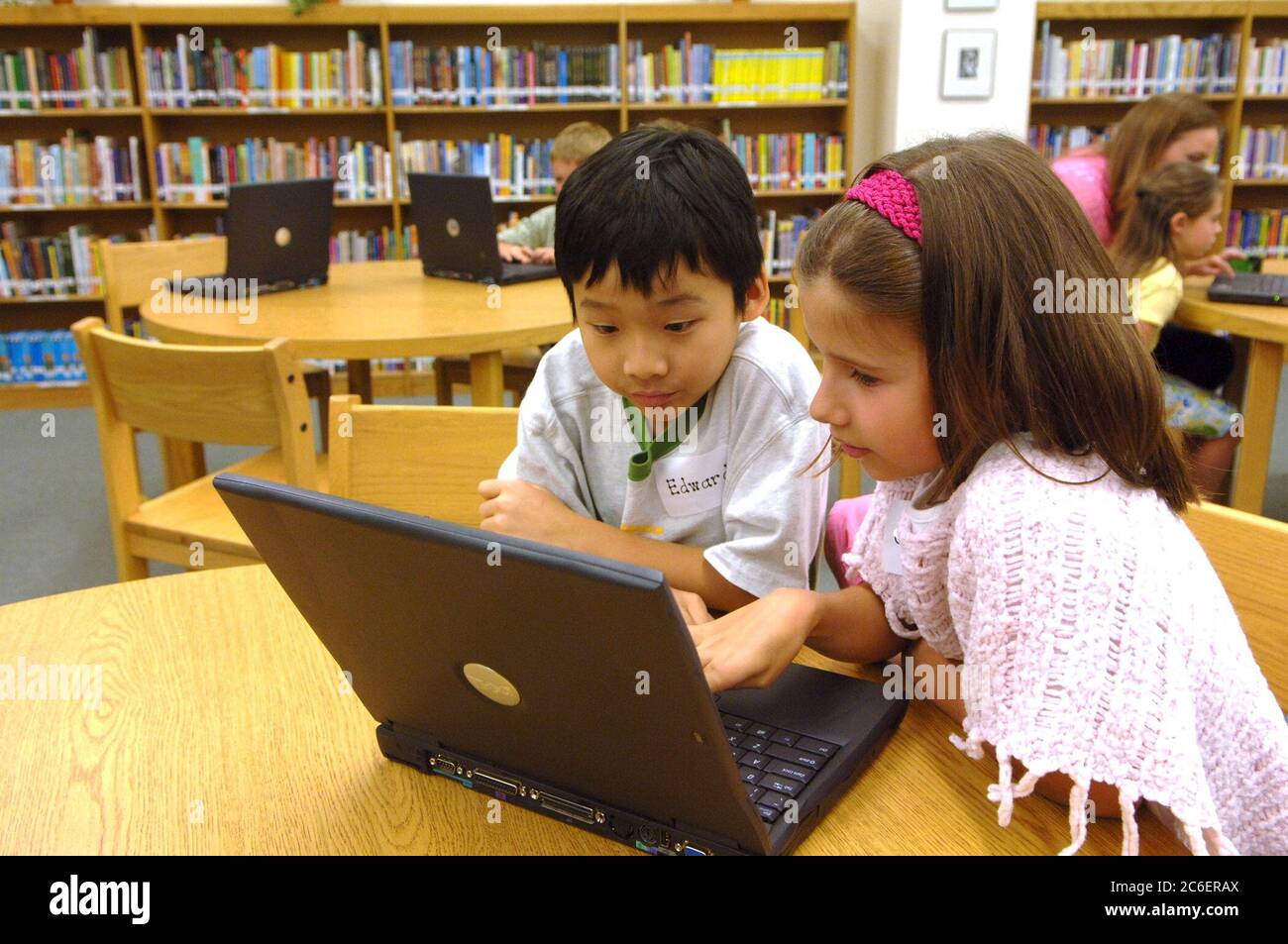 Austin, Texas USA, 19 aprile 2005: I bambini di seconda elementare guardano il programma di sicurezza Internet per bambini sui computer portatili della biblioteca scolastica durante l'evento di avvio per il "Cyber-Guardian for the Internet Age: Faux Paw the Techno Cat." ©Bob Daemmrich Foto Stock