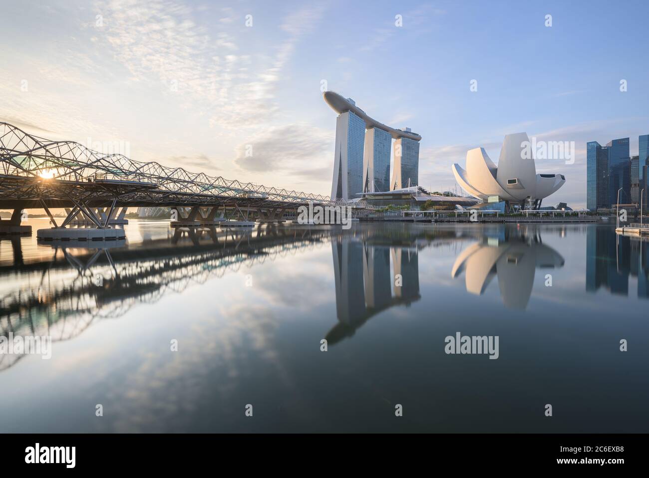 Singapore - 19 Dic 2019: Una vista composita del Ponte di Helix, dell'hotel Sands Resort e del Museo ArtScience che si riflette sul bacino idrico di Marina Bay Foto Stock
