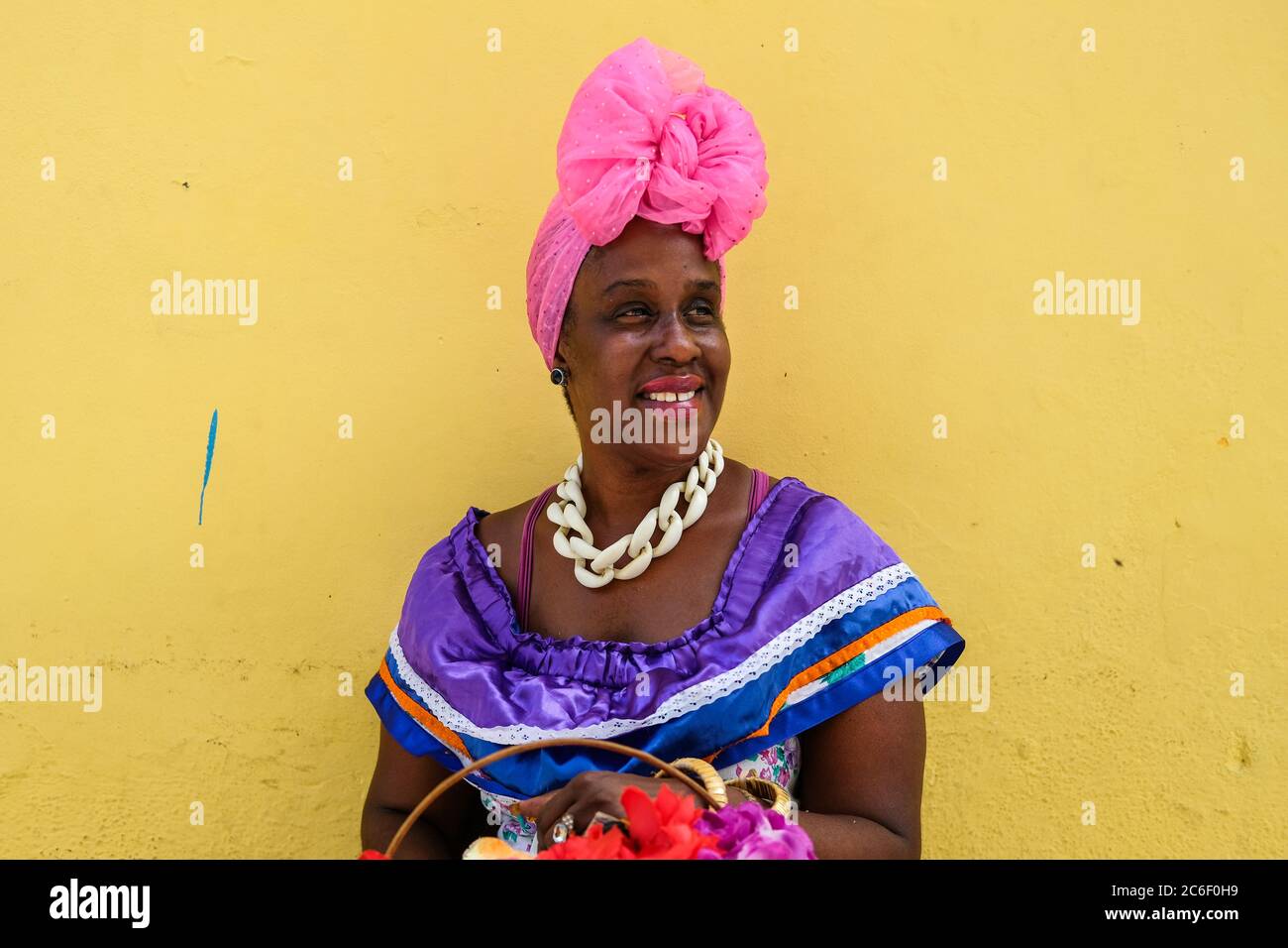 Un cubano vestito di colore si trova sul lato della strada in Habana Vieja a l'Avana, Cuba. Foto Stock