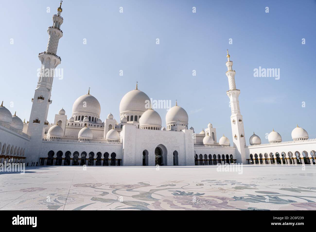 Vista del cortile interno e delle sue cupole della moschea di Abu Dhabi durante una giornata di sole con un cielo blu Foto Stock