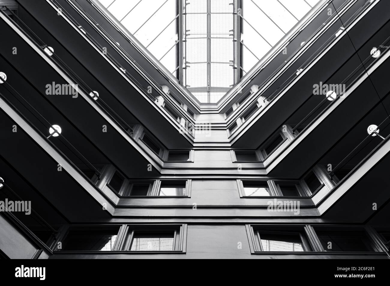 Vista ad angolo basso di un edificio con le sue finestre rettangolari e tetto con cielo nuvoloso sullo sfondo Foto Stock