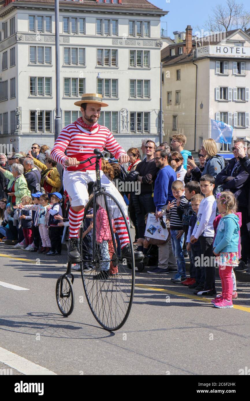 Zurigo, Svizzera - 23. 2017 aprile: L'uomo guida una bicicletta d'epoca nella sfilata di Sechselauten. Sechselauten è una tradizionale vacanza primaverile nella città di Foto Stock
