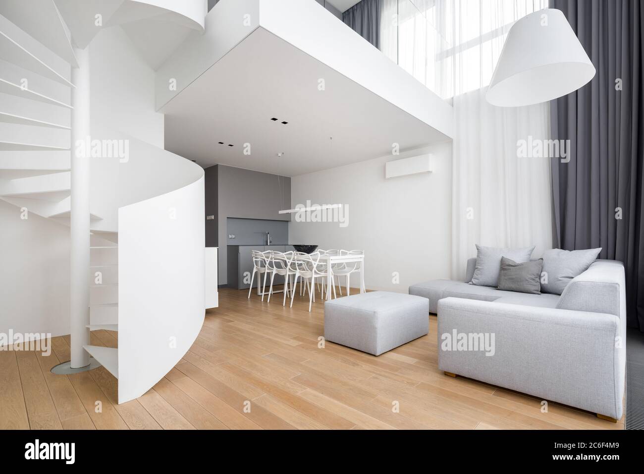 Appartamento moderno con bianco, scala a chiocciola e grande divano Foto Stock